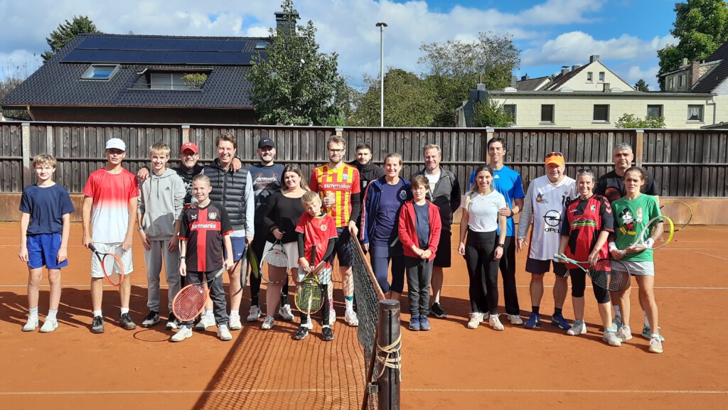 Mehrere Tennisspieler*innen auf einer Tennisanlage